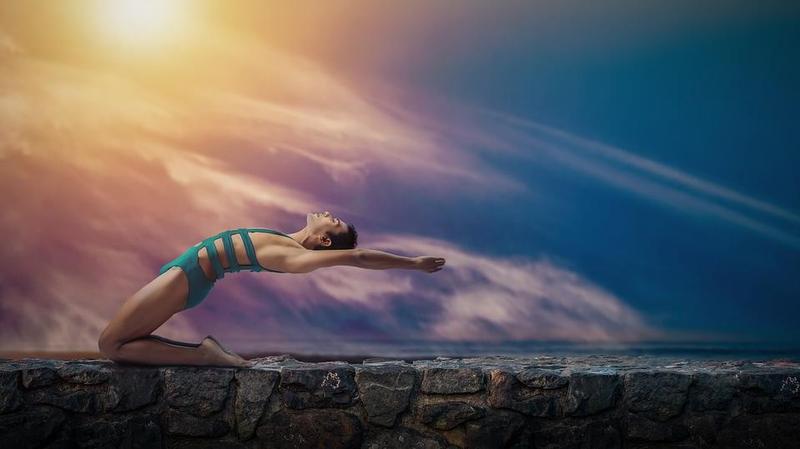 woman ina yoga pose leaning back and to the sky 