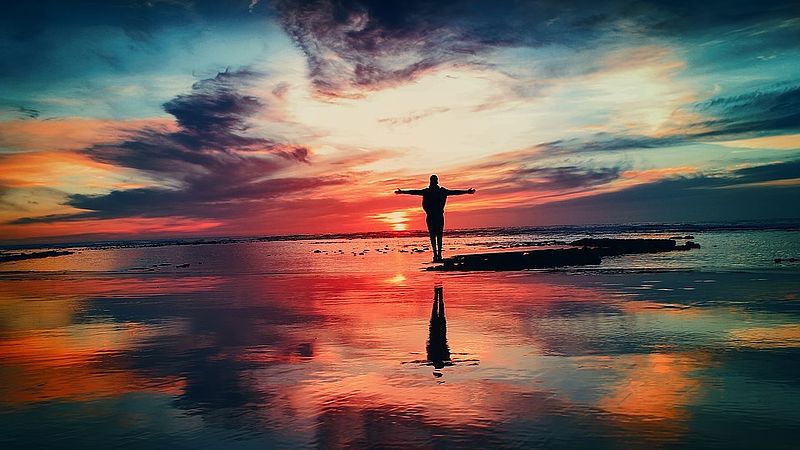 man embracing a colourful sunset