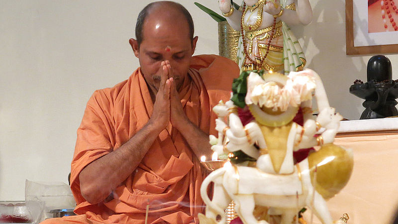 Swami Nivedananda bowing down during a puja